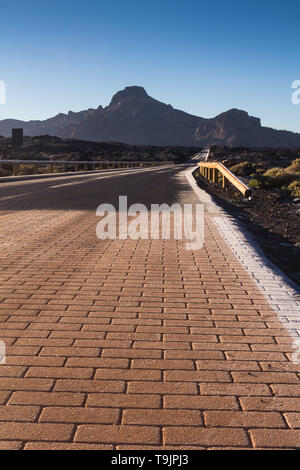 Hohe Qualität der Straßen in den Teide Nationalpark. Straßen von tuf Steine und Berge gesäumt ist. Dünne Schicht von einem Frost auf der Straße in einem frühen Morgen. Stockfoto