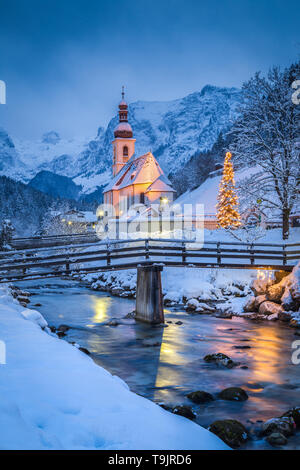 Schöne Dämmerung Blick auf Sankt Sebastian Wallfahrtskirche mit geschmückten Weihnachtsbaum während der Blauen Stunde leuchtet in der Dämmerung im Winter, Ramsau, Nat Stockfoto