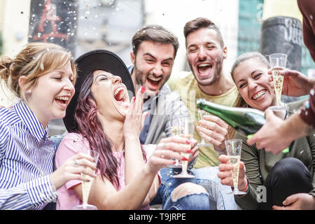 Gruppe der glücklichen Freunde Partei werfen von Konfetti und trinken Champagner Outdoor - Junge Leute Spaß Geburtstag zusammen feiern. Stockfoto