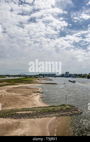 Nijmegen, Niederlande, April 25, 2019: Blick von der Stadtbrücke De Oversteek auf die Auen des Flusses Waal, mit Stränden, Wellenbrecher und Stockfoto