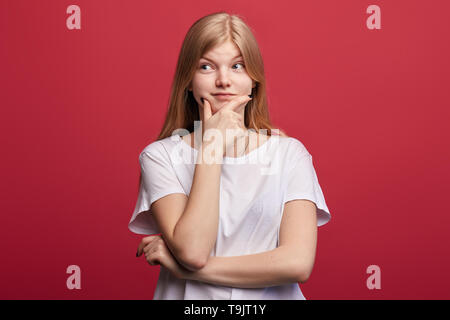 Junge hübsche Frau mit der Hand über das Kinn zur Seite suchen, sie ist yhinking über ihre Zukunft leben, Urlaub, Wochenende, Student, aus denen ein Plan, Projekt Stockfoto