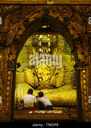 Mandalay, Myanmar - Feb 9, 2017. Menschen verehrten Buddha Statue mit dem goldenen Papier an Mahamuni Tempel in Mandalay, Myanmar. Stockfoto