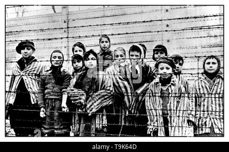 AUSCHWITZ KINDER gefangene Kind Gefangenen tragen gestreifte Uniformen starren heraus von hinter einem Stacheldrahtzaun in berüchtigten WW2 NS-Tod-lager Auschwitz im südlichen Polen. Zweiter Weltkrieg Stockfoto