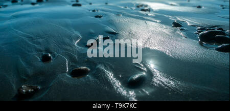 Kieselsteine am Strand mit Sonnenlicht bei Ebbe. Meer wallpaper oder Hintergrund. Natur zen Ruhe Ruhe Entspannung Konzepte. Stockfoto