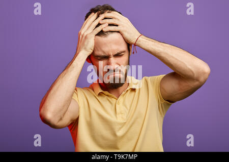 Emotionale schöner Mann hat harte Zeit. Bursche Depression, der Mensch ist über die Trennung mit Freundin kümmern. bis Foto schliessen. weinenden Mann seinen Kopf halten, er seinen besten Freund verloren hat. Stockfoto
