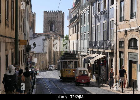 Lissabon, Portugal - Oktober 01, 2018: Blick auf eine Straße in der historischen Altstadt von Alfama mit der Straßenbahnlinie 12 im Hintergrund in Lissabon, Portugal. Stockfoto