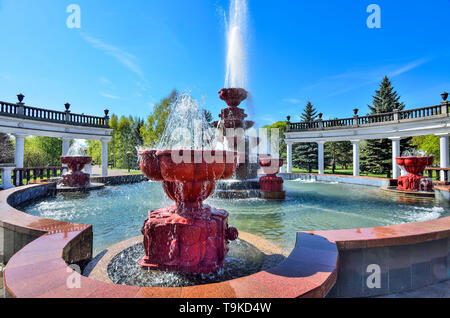 Novokuznetsk, Russland - 19. Mai 2019: alte Brunnen im Stadtpark. Kaltes Wasser aus Stein fünf Ebenen Brunnen am sonnigen Tag fließt. Konzept Stockfoto