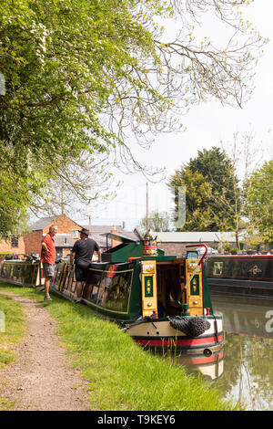 Zwei Männer stehen auf einem Kanal Leinpfad neben einem bunt bemalten 15-04. Sie haben ihre Boote in Bereitschaft für den Crick Boat Show vertäut. Stockfoto