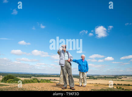 90 Jahre alter Mann nimmt seine Frau, die einen schweren Sehverlust auf dem Land in Wiltshire, in der Natur und weg von Ihrem Haus zu erhalten. Stockfoto