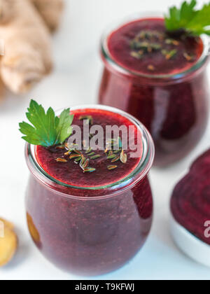 Frische rote Bete und Ingwer Wurzel Smoothie. Rote-bete-Smoothie in Glas Glas auf weißer Tisch. Flache Freiheitsgrad. Kopieren Sie Platz für Text. Sauber essen und detox Konzept, Rezept Idee. Stockfoto