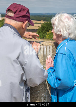 90 Jahre alter Mann nimmt seine Frau, die einen schweren Sehverlust auf dem Land in Wiltshire, in der Natur und weg von Ihrem Haus zu erhalten. Stockfoto