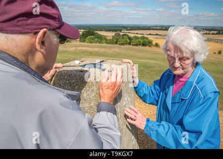 90 Jahre alter Mann nimmt seine Frau, die einen schweren Sehverlust auf dem Land in Wiltshire, in der Natur und weg von Ihrem Haus zu erhalten. Stockfoto