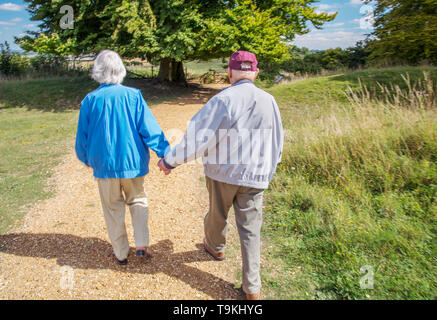 90 Jahre alter Mann nimmt seine Frau, die einen schweren Sehverlust auf dem Land in Wiltshire, in der Natur und weg von Ihrem Haus zu erhalten. Stockfoto