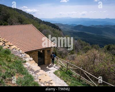 Im mittleren Alter weibliche Wanderer genießen der Landschaft an der Virgen de la Cueva Kapelle, ein Wanderziel in der Nähe von Mount Oroel, Jaca, Spanien Stockfoto