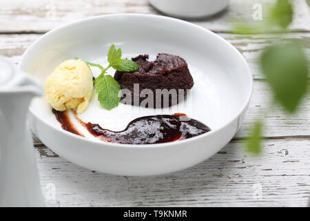 Die leckere, süße Nachspeise, Kuchen, Eis und Obst auf einem weißen Teller. Horizontale Zusammensetzung Stockfoto