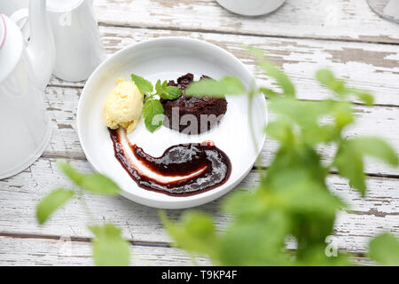 Die leckere, süße Nachspeise, Kuchen, Eis und Obst auf einem weißen Teller. Horizontale Zusammensetzung Stockfoto