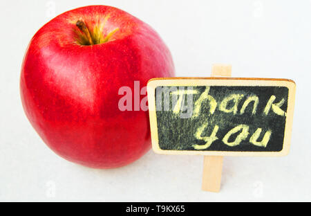 Apple mit vielen Dank Inschrift auf einem Holzbrett schwarzer Hintergrund Stockfoto