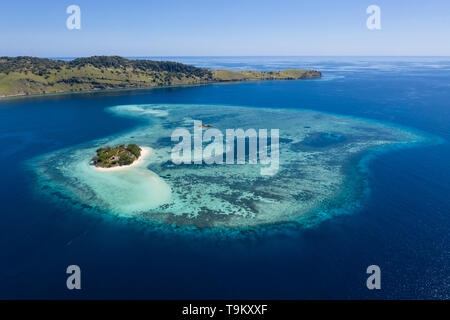 Aus der Vogelperspektive, einem idyllischen tropischen Insel ist durch ein gesundes Korallenriff im Komodo National Park, Indonesia umgeben. Stockfoto