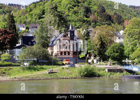 Riverside Dorf am Rhein in Deutschland mit Bäumen bedeckten Hügel im Hintergrund Stockfoto