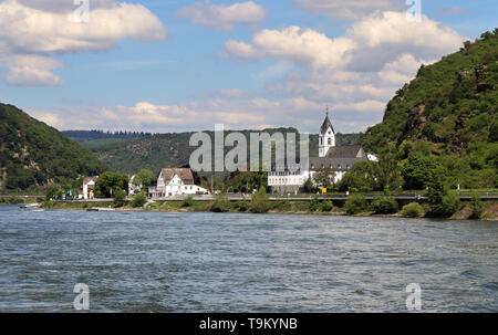 Riverside Dorf am Rhein in Deutschland mit Bäumen bedeckten Hügeln im Hintergrund Stockfoto