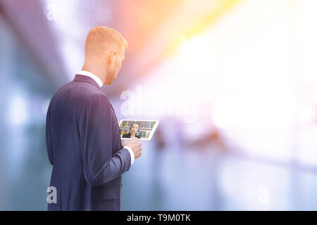 Mann in Bürogebäude, einen on-line-Anruf mit Tablet-PC, Text oder Kopie Raum Stockfoto