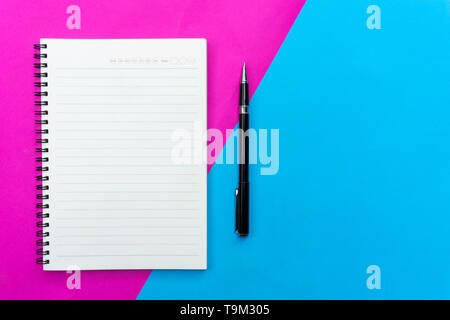 Ansicht von oben leer Notebook und schwarzen Stift für Mockup flach auf Blau und Rosa Hintergrund. Stockfoto