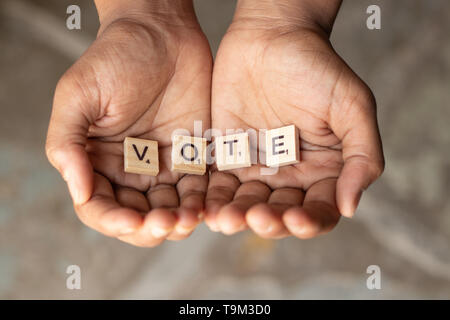 Maski, Indien - 14. Mai, 2019: Konzept der Betteln für Stimmen, Holz- Buchstaben in der hohlen Hand, die Geste des Bettelns, empfangen. Stockfoto