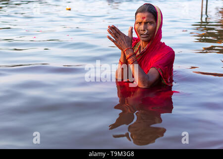 Varanasi, Indien, 27. März 2019 - Hinduistische Frau im Sari, die mit den Göttern in Ganga Fluss in Varanasi, Indien Stockfoto