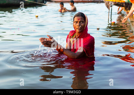 Varanasi, Indien, 27. März 2019 - Hinduistische Frau im Sari, die mit den Göttern in Ganga Fluss in Varanasi, Indien Stockfoto