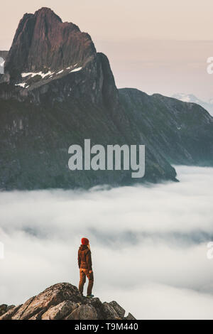 Wanderer Mädchen an der Klippe Rand über den Wolken reisen in die Berge, die alleine stehen Abenteuer extreme Reise outdoor Norwegen aktiv Urlaub Stockfoto