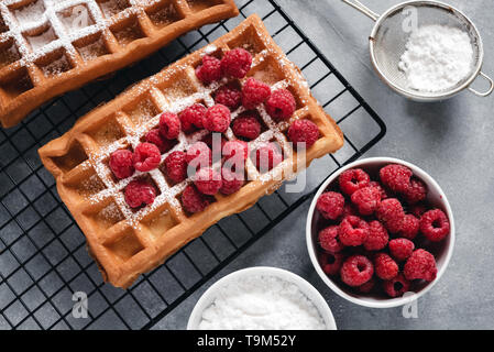 Selbstgemachte Waffeln mit Himbeeren auf grau Tabelle Stockfoto