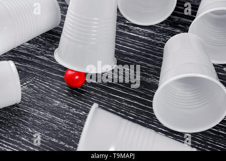 Die Schale in der Schale Spiel mit einem roten Ball. Um Lüge leere verlieren Cups. Das Konzept der Bargeld Gewinne im Glücksspiel Stockfoto