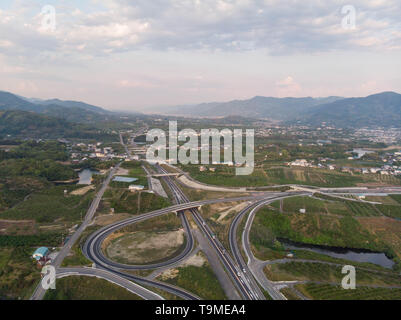 Luftaufnahme der ländlichen Expressway mit Berge und Wolken in der Ferne Stockfoto