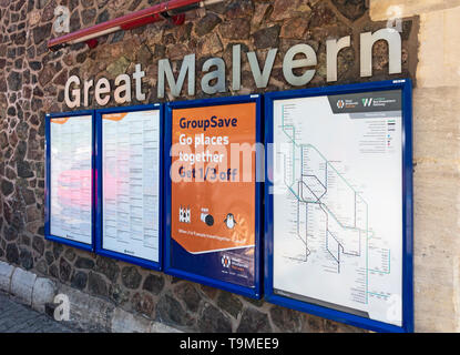 Aushänge/Informationstafeln an der Wand außerhalb der Bahnhof Great Malvern in Malvern, Worcestershire, England, Großbritannien, einschließlich Zeitplänen, einer Einspritzrampe net Stockfoto