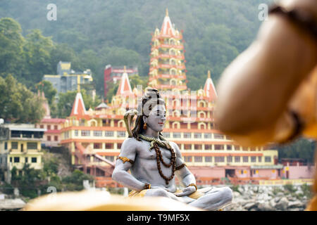 (Selektive Fokus) Atemberaubende Aussicht auf die Statue von Lord Shiva sitzen am Ufer des Ganges. Verschwommen Trimbakeshwar Tempel in der backgrou Stockfoto