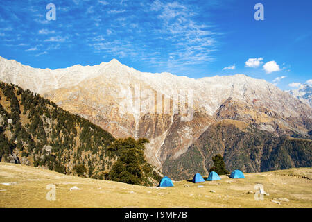 Blaue Zelte im Vordergrund und die schönsten Gipfel des Himalaya Gebirge im Hintergrund. Sonnigen Tag mit einigen Wolken. Dharamshala, Himachal Prad Stockfoto