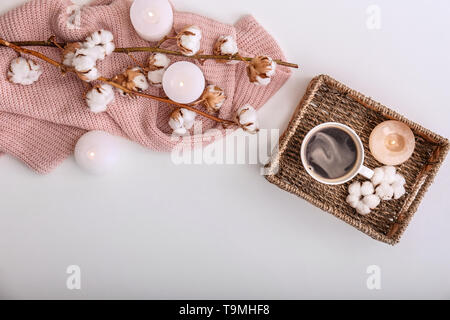 Komposition mit Tasse Kaffee, brennende Kerzen und Baumwolle Blumen auf weißem Hintergrund Stockfoto