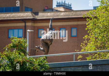 Bronzestatue von Kricketspieler Sir Alec Bedser auf bedser Brücke, eine Fußgängerbrücke auf der Basingstoke Canal verbindet WWF-UK Hauptquartier in die Innenstadt Stockfoto