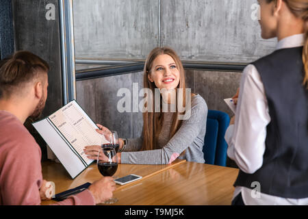 Kellnerin Bestellaufnahme und vom jungen Paar im Restaurant Stockfoto