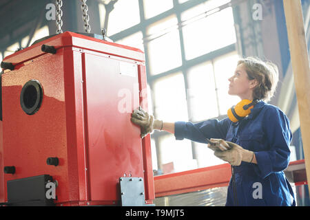 Weibliche Mover Arbeiten im Werk Stockfoto