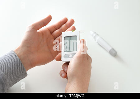 Man misst Blutzuckerspiegel mit digitalen glucometer, Nahaufnahme. Diabetes Control Stockfoto