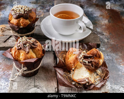Hausgemachte Muffins und Tee auf einem rustikalen Holzmöbeln Hintergrund. Close-up Stockfoto