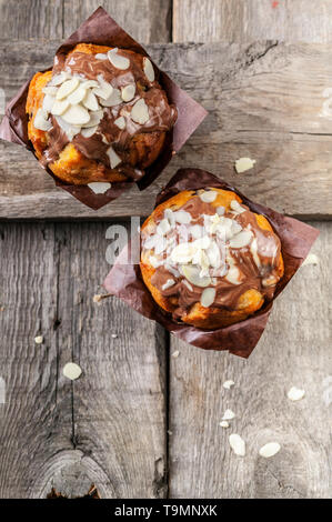 Close-up-Muffins mit Schokolade und Mandeln auf einem urigen Hintergrund. Ansicht von oben Stockfoto