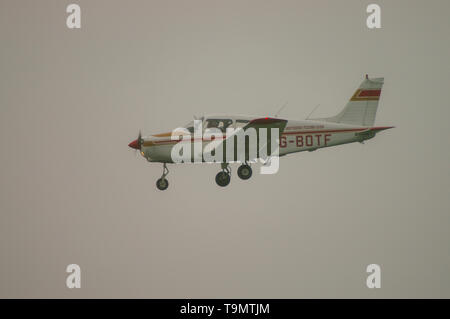 PIPER PA-28-151 Cherokee Warrior, das bei schlechtem Wetter landet. Privater Pilot, der im Nebel fliegt, nebeliger Himmel. Niedrige Wolke Stockfoto