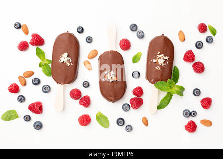 Schokoladeneis Pops und Beeren flach auf weißem Hintergrund legen. Tabelle Ansicht von oben. Sommer Konzept Stockfoto