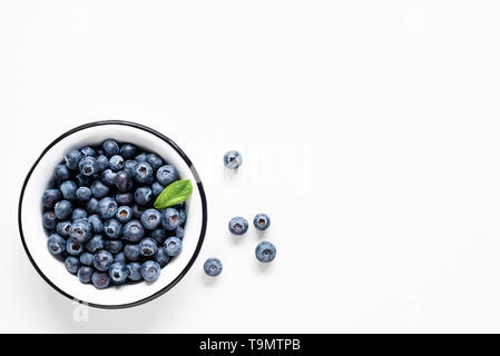 Bio Blaubeeren in Schüssel auf weißem Hintergrund. Tabelle Ansicht von oben. Kopieren Sie Platz für Text Stockfoto