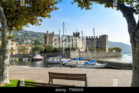 TORRI del Benaco, Gardasee, Italien - September 2018: die malerische Landschaft Blick auf den kleinen Hafen von Torri del Benaco am Gardasee, von Bäumen eingerahmt Stockfoto