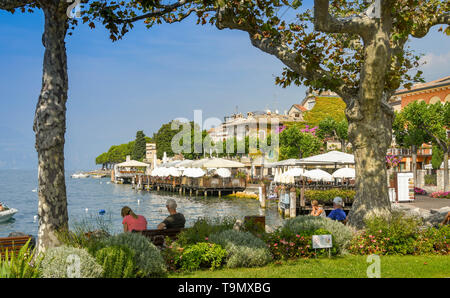 TORRI del Benaco, Gardasee, Italien - September 2018: die malerische Landschaft Ansicht von Torri del Benaco am Gardasee von Bäumen und Zweigen gerahmt. Stockfoto