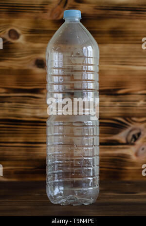 Plastikwasserflasche auf dem hölzernen Tisch Stockfoto