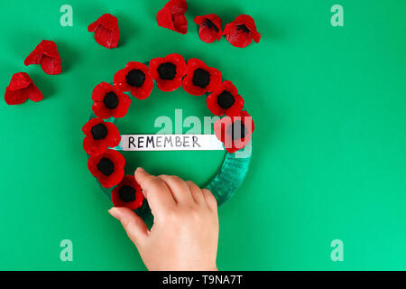 14 Diy Kranz roter Mohn Anzac Day, Erinnerung, denken Sie daran, Memorial Day aus Pappe Ei-tabletts auf grünem Hintergrund. Geschenk Idee, Dekor. Schritt für Schritt Stockfoto